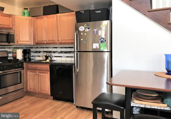 a kitchen with stainless steel appliances a refrigerator a stove a sink and a microwave