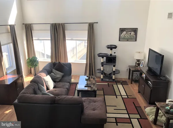 a living room with furniture a flat screen tv and a large window