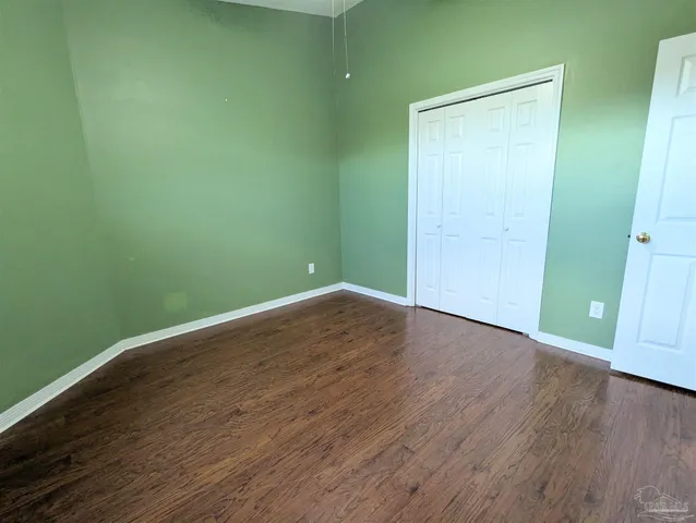 an empty room with wooden floor and closet