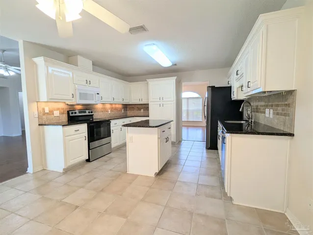 a kitchen with stainless steel appliances granite countertop a refrigerator and a stove