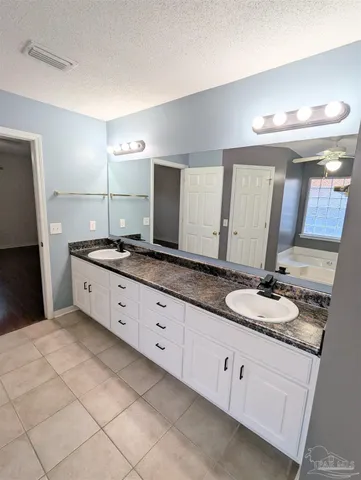 a spacious bathroom with a granite countertop sink and a mirror
