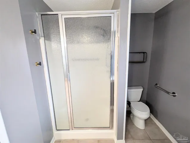 a bathroom with a granite countertop toilet and a shower