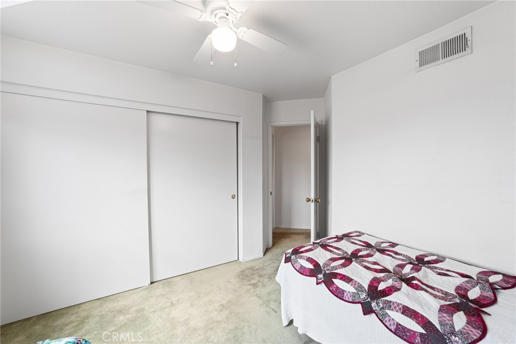 28962 Clear Spring Lane Highland, CA 92346 - Photo 22 of 32 a bedroom with a bed and a chandelier