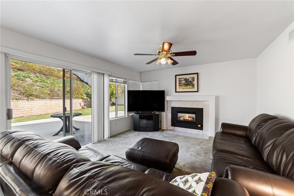 28962 Clear Spring Lane Highland, CA 92346 - Photo 8 of 32 a living room with furniture ceiling fan and a fireplace