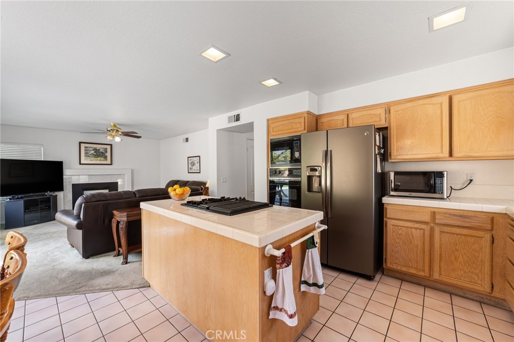 28962 Clear Spring Lane Highland, CA 92346 - Photo 10 of 32 a kitchen with stainless steel appliances granite countertop a refrigerator a stove a sink a dining table and chairs