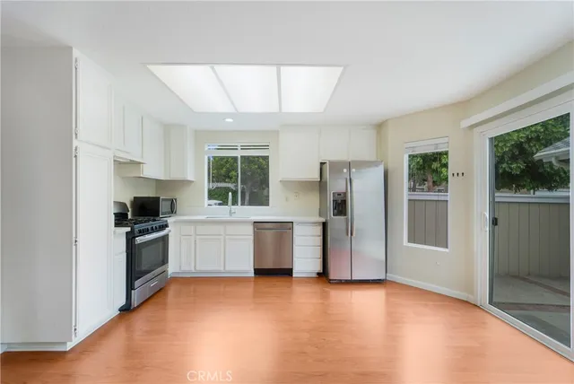 a kitchen with a refrigerator and a stove top oven