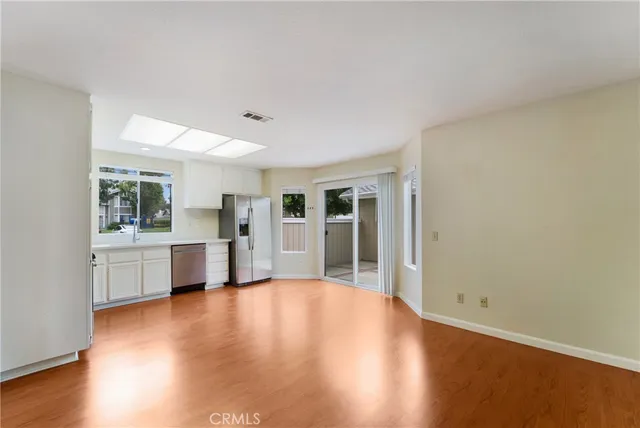 a view of a big room with wooden floor and windows