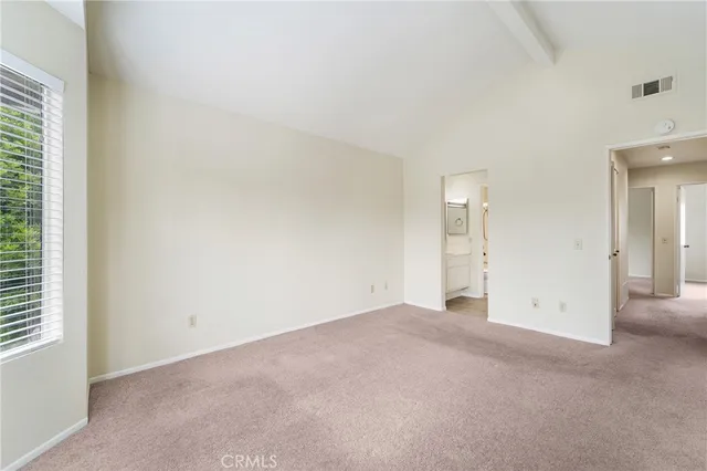 an empty room with windows and bathroom view