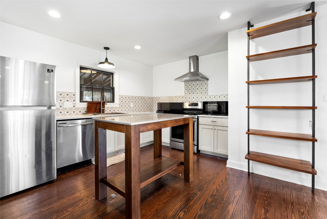 517 North Ave F Elgin, TX 78621 - Photo 10 of 21 a kitchen with stainless steel appliances a stove a sink dishwasher a refrigerator and wooden floor