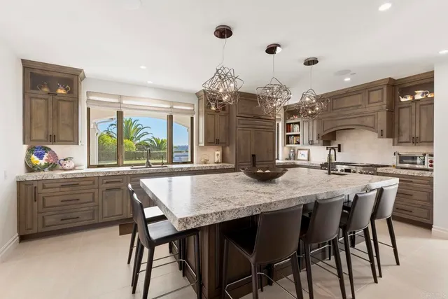 a dining hall with stainless steel appliances kitchen island granite countertop a dining table and chairs