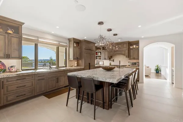 a dining hall with stainless steel appliances kitchen island granite countertop a dining table and chairs