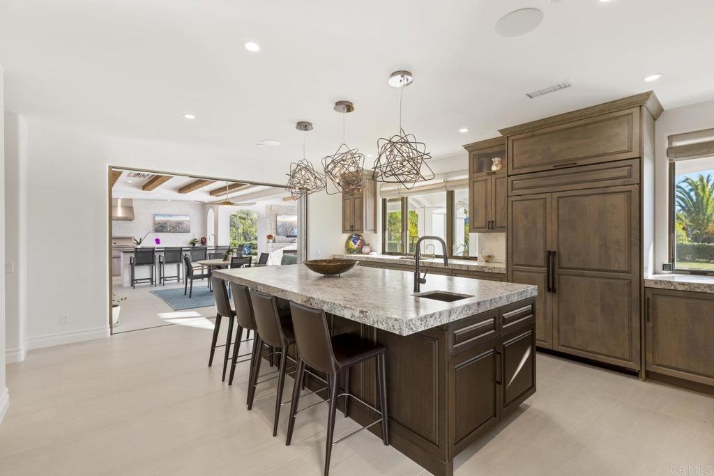 3226 Violet Ridge Encinitas, CA 92024 - Photo 15 of 54 a dining hall with stainless steel appliances kitchen island granite countertop a dining table and chairs