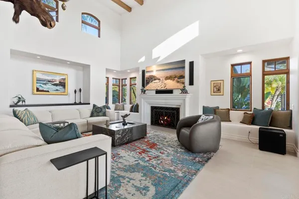 a living room with furniture a rug and a floor to ceiling window