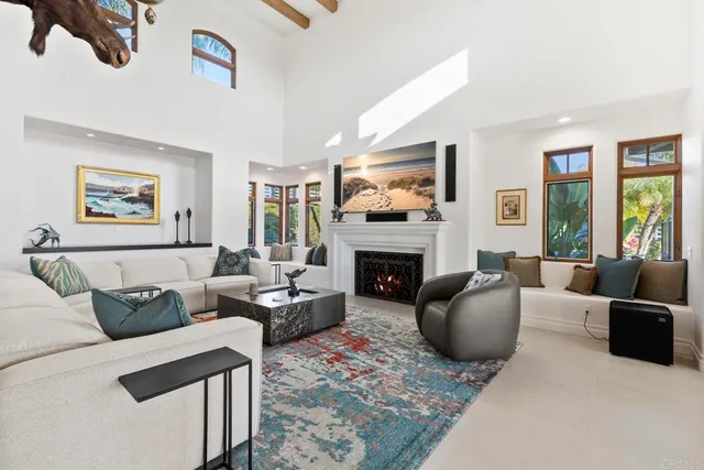 a living room with furniture a rug and a floor to ceiling window