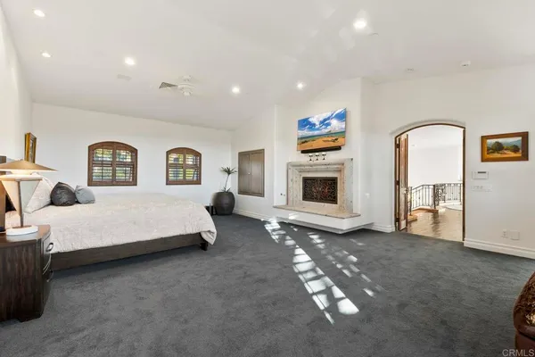 a spacious bedroom with a bed and a chandelier