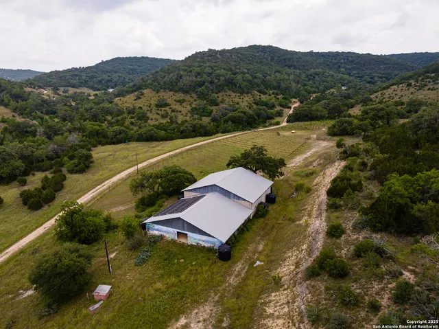an aerial view of residential houses with outdoor space and trees