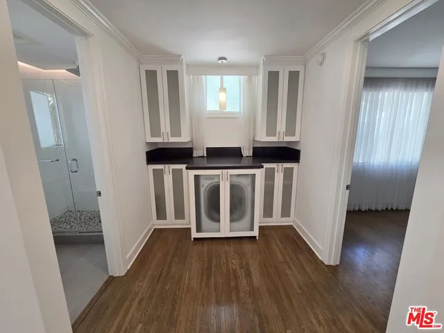 a hallway with wooden floor and closet