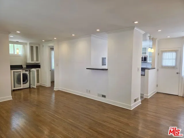 a view of a kitchen with furniture and wooden floor