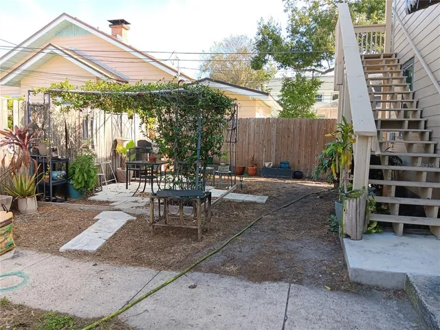 a patio with a table and chairs and potted plants