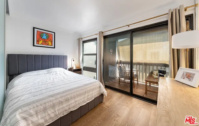 a spacious bedroom with a balcony a bed and a large window