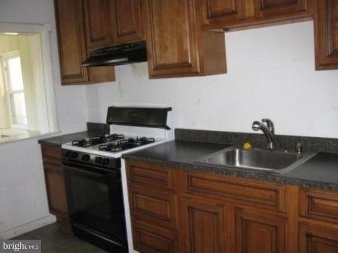 3733 Clarinth Road Baltimore, MD 21215 - Photo 3 of 5 a kitchen with granite countertop a sink stove and cabinets