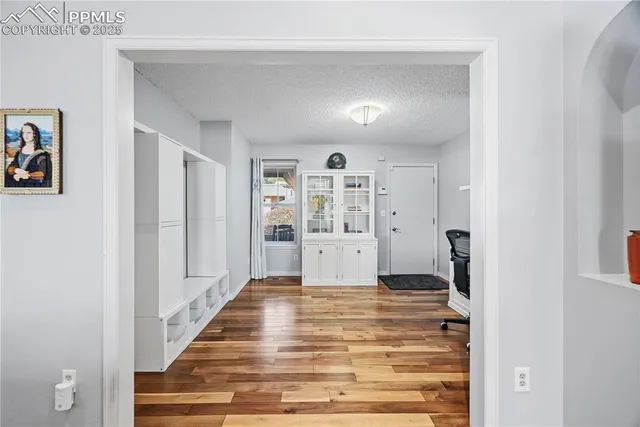 a view of a hallway with wooden floor and windows