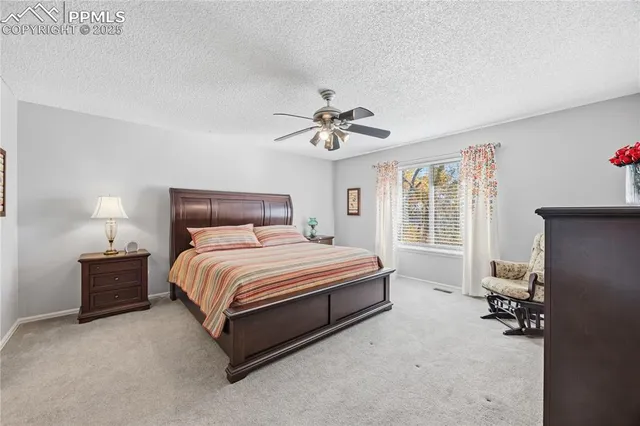 a spacious bedroom with a bed and a ceiling fan