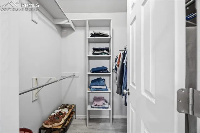 a view of walk in closet with clothes and shoes