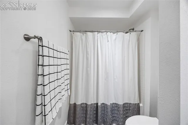 a bathroom with a shower curtain and a toilet