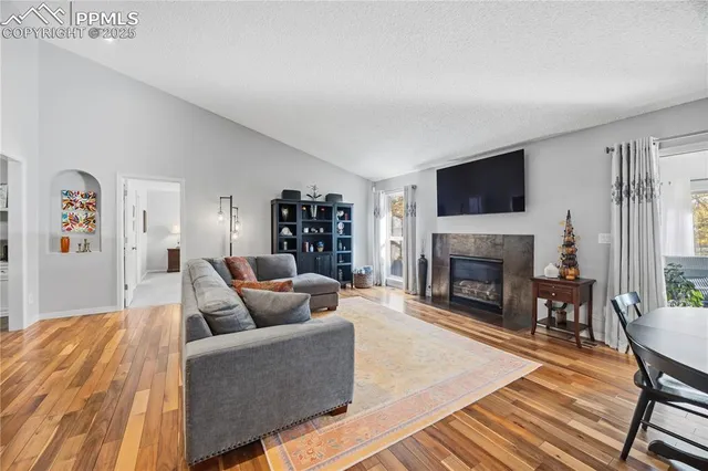 a living room with furniture a flat screen tv and a fireplace