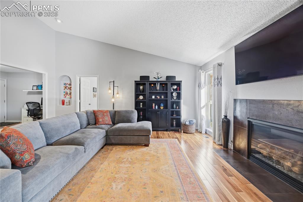 2135 Glenhill Road Colorado Springs, CO 80906 - Photo 10 of 50 a living room with furniture a fireplace and a flat screen tv
