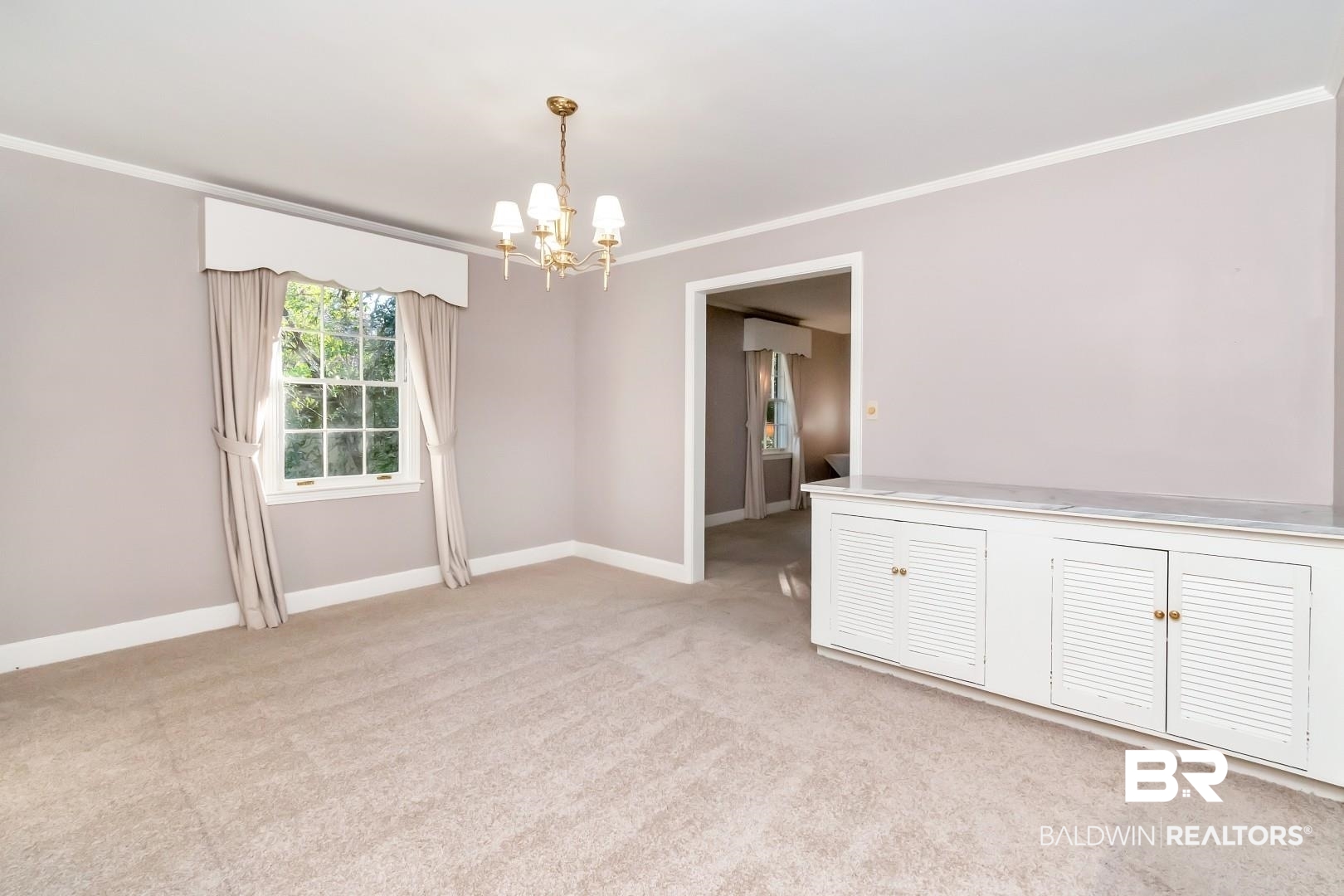 308 Brawood Drive Mobile, AL 36608 - Photo 6 of 33 Unfurnished room featuring light colored carpet, crown molding, and a chandelier