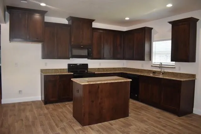 a kitchen with a sink and a stove top oven