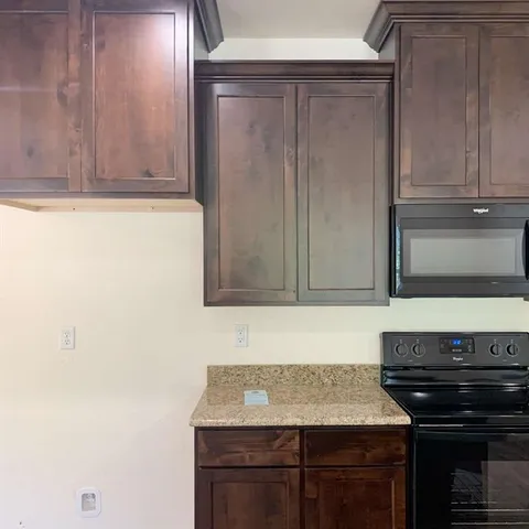 a kitchen with granite countertop cabinets stove and oven