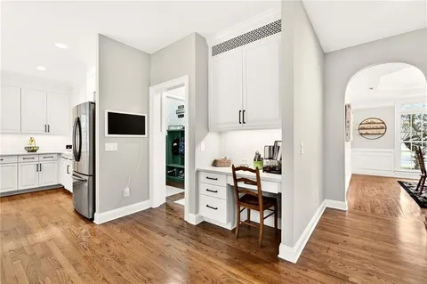 a view of kitchen with stainless steel appliances wooden floor and cabinets