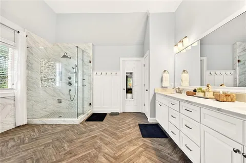 a bedroom with a double vanity sink and mirror