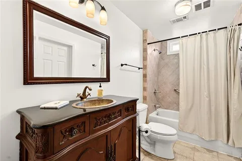 a bathroom with a sink a toilet a mirror and shower