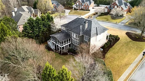 a view of a white house with a yard and sitting area