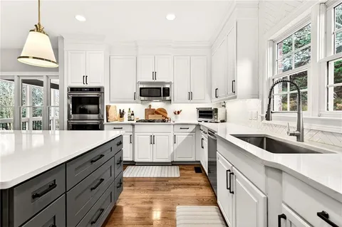 a kitchen with stainless steel appliances a stove sink microwave and cabinets