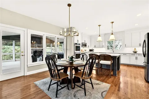 a view of a dining room and livingroom with furniture wooden floor a chandelier