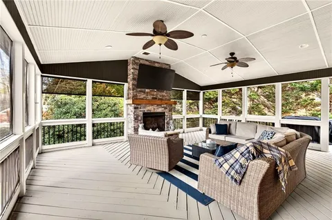 a living room with furniture large windows and fireplace