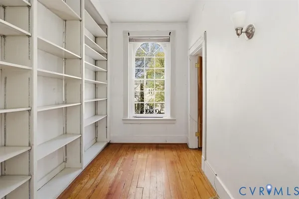 an empty room with wooden floor and windows