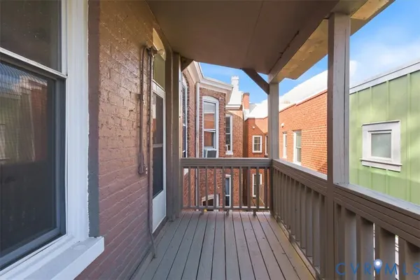 a view of a wooden house with a large tree and wooden fence