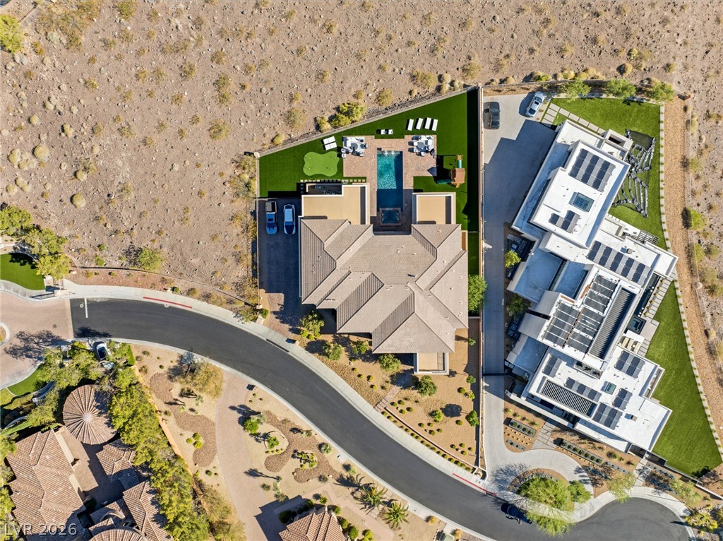 5 Crystal Tree Pass Henderson, NV 89052 - Photo 50 of 67 An aerial perspective reveals a luxurious desert oasis, featuring multiple structures, a pool, and manicured green spaces.