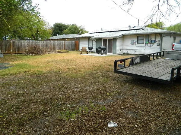 a view of a patio with table and chairs potted plants and wooden fence