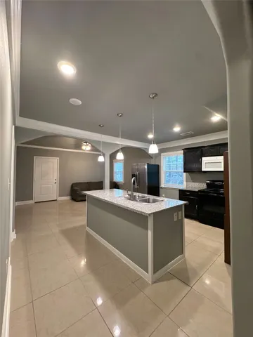 a view of kitchen with kitchen island a sink and a stove