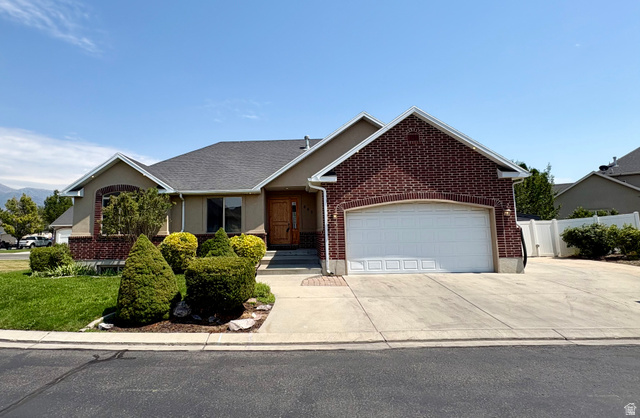 665 West State Road Lehi, UT 84043 - Photo 1 of 30 Brick and stucco exterior featuring an attached two-car garage with a white panel door, a concrete driveway, and a front walk leading to the entryway