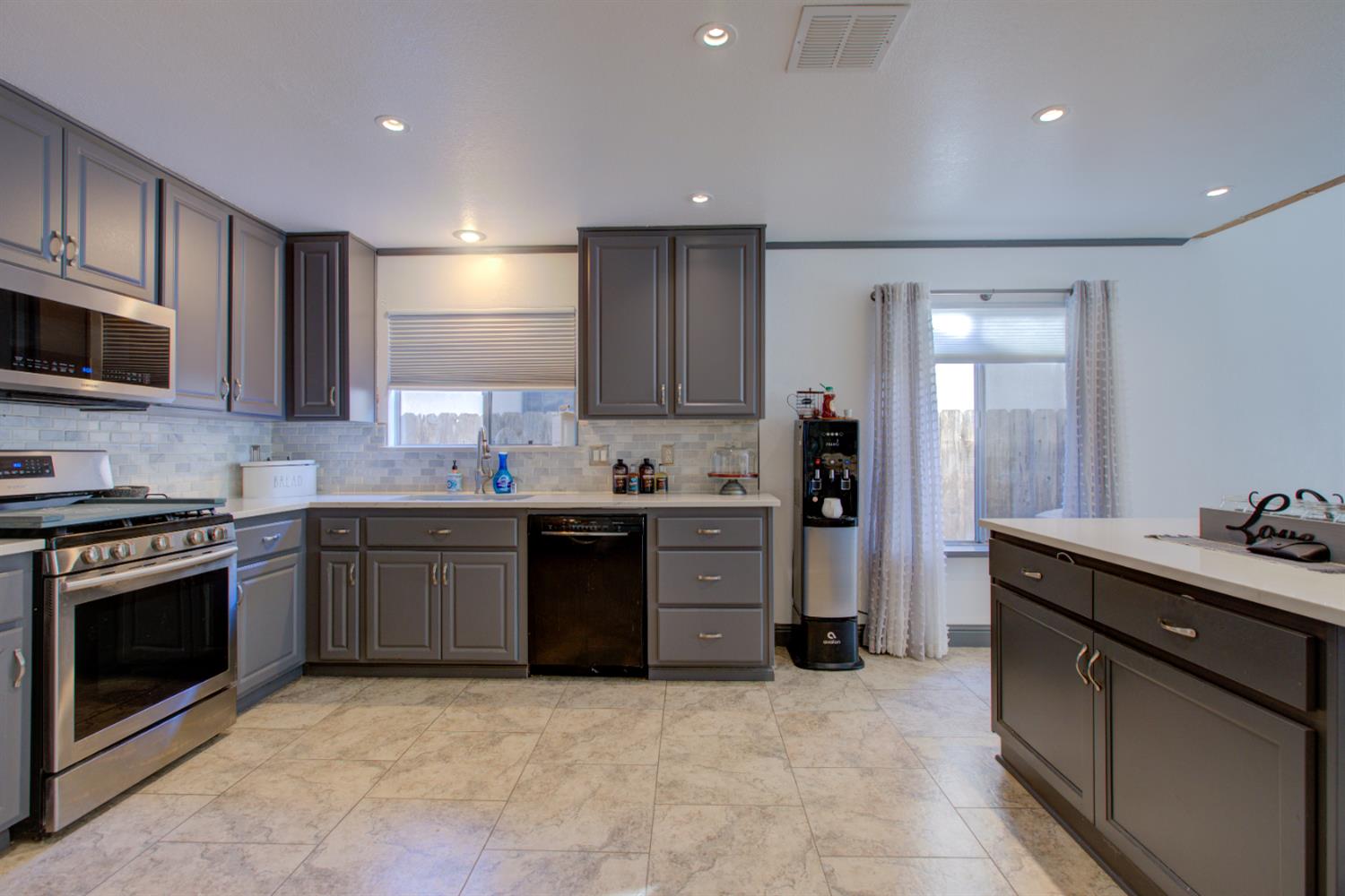 604 Kinshire Way Patterson, CA 95363 - Photo 14 of 42 a kitchen with stainless steel appliances granite countertop a stove sink and cabinets