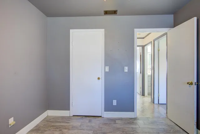 a bedroom with a bed a dresser and flat screen tv