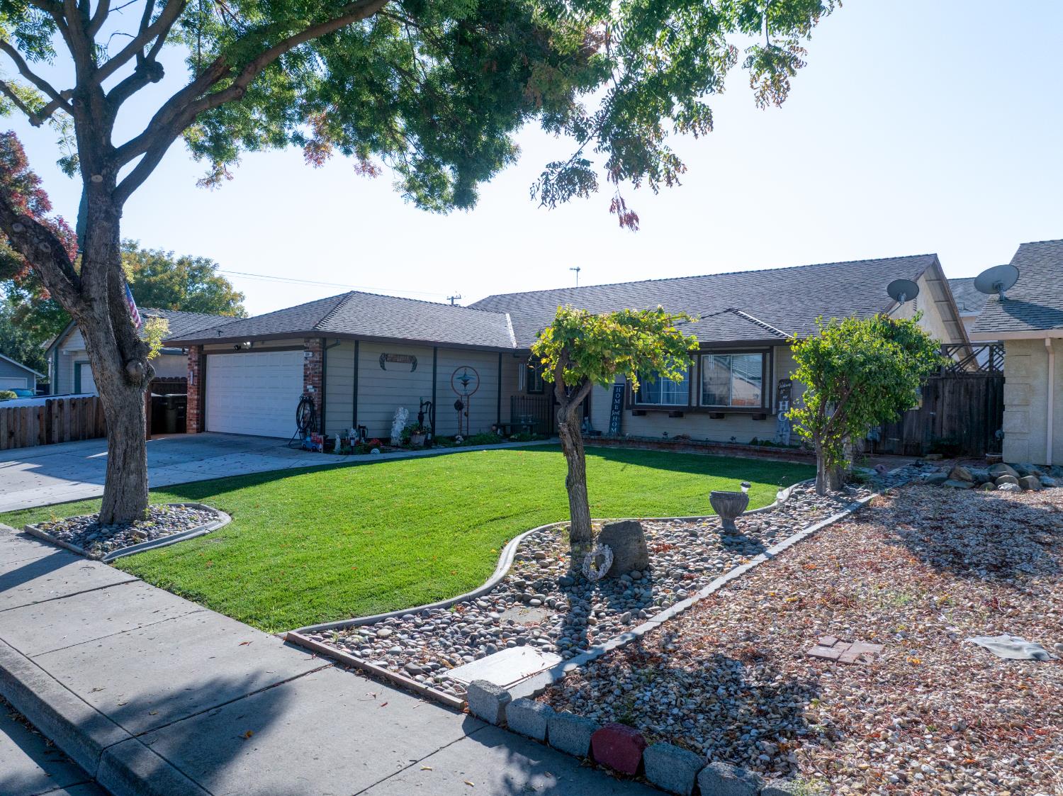 604 Kinshire Way Patterson, CA 95363 - Photo 4 of 42 a view of a house with a yard and a table and chair under an umbrella